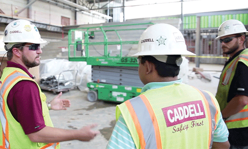 people in hard hats discussing at a construction site